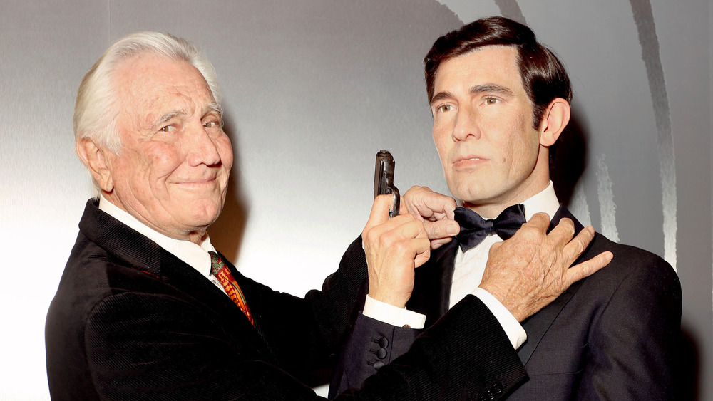 George Lazenby pose avec son cire de James Bond