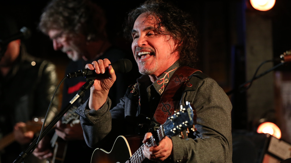 John Oates de Hall & Oates souriant et chantant dans un microphone 