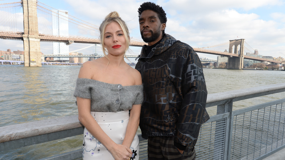 Sienna Miller et Chadwick Boseman devant le pont