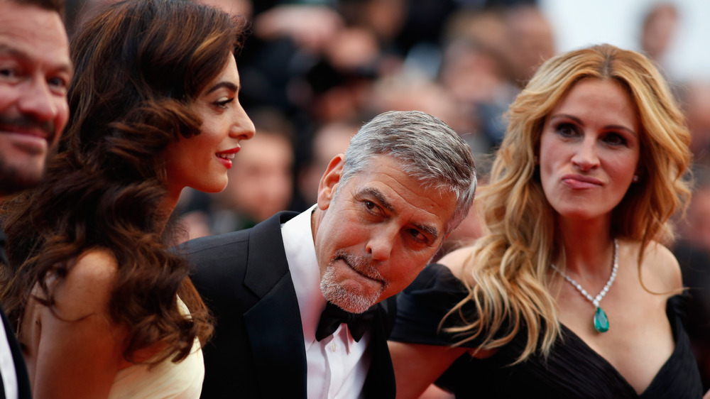 Amal Clooney, George Clooney et Julia Roberts posant sur le tapis rouge