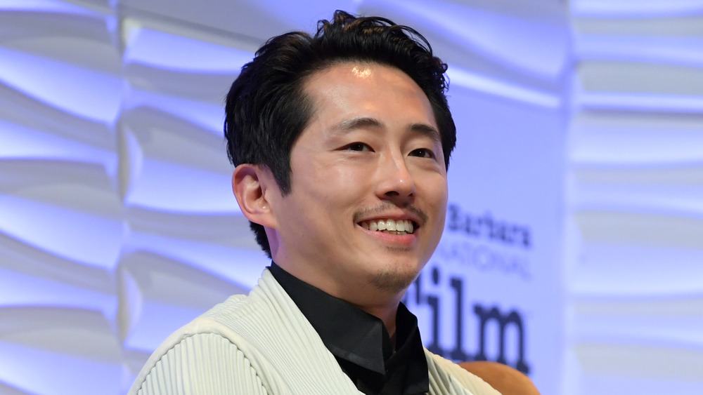 Steven Yeun souriant sur scène