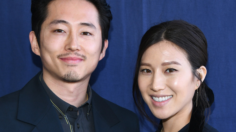 Steven Yeun souriant à côté de sa femme Joana Pak