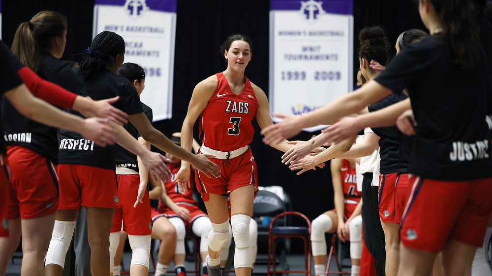 Jenn Wirth sourit alors qu'elle donne des high-fives à ses coéquipiers sur le terrain