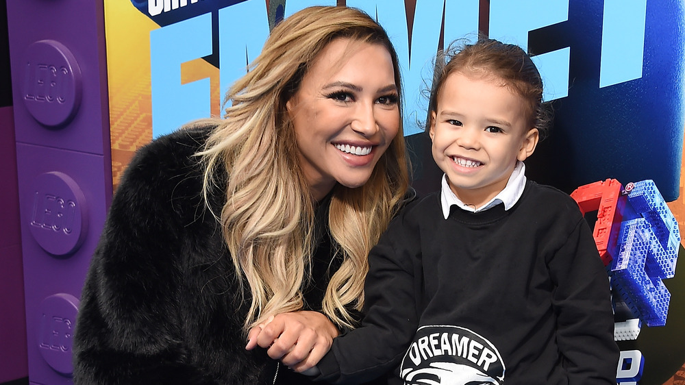 Naya Rivera accroupie et souriante tenant la main de son fils, Josie Hollis Dorsey