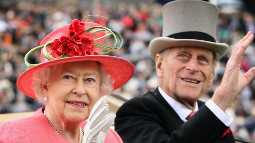 Le prince Philip et la reine Elizabeth saluant une foule