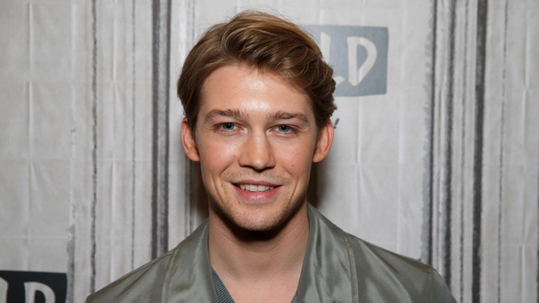 Joe Alwyn sourit sur le pas et répète