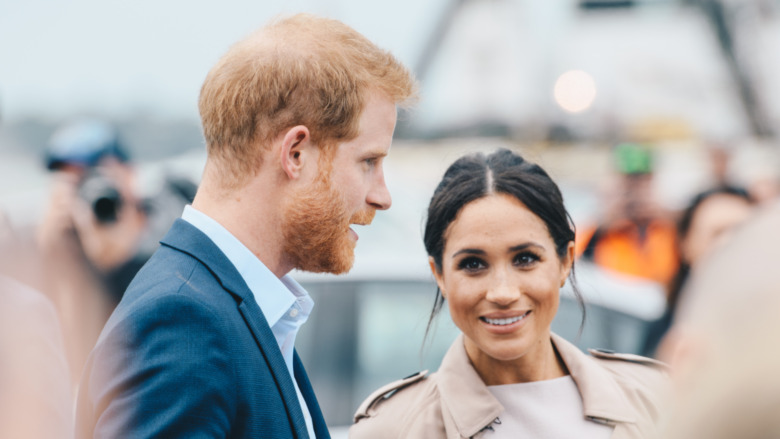 Le prince Harry et Meghan Markle souriant dans une foule