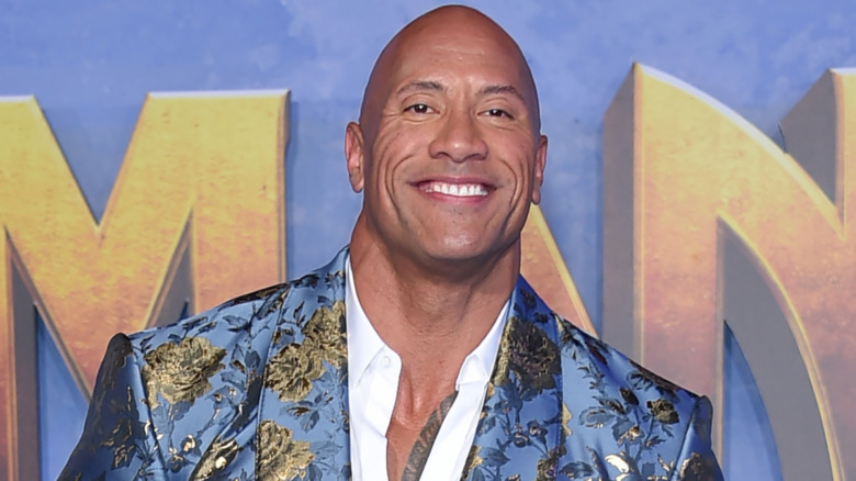 Dwayne Johnson souriant sur le tapis rouge 