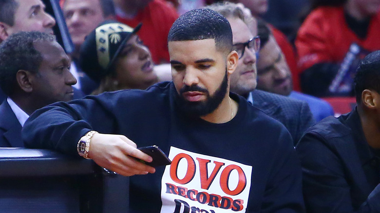 Drake regardant son téléphone