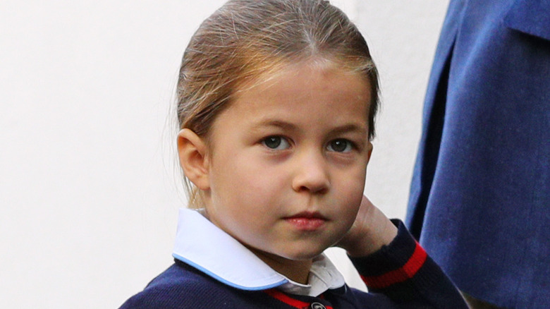 La princesse Charlotte touchant ses cheveux et levant les yeux