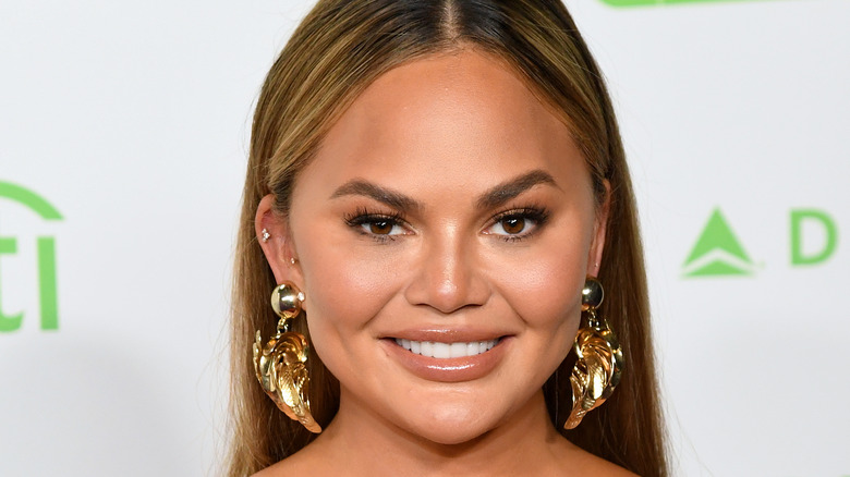 Chrissy Teigen porte des boucles d'oreilles en or