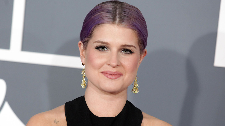 Kelly Osbourne aux cheveux violets et souriant