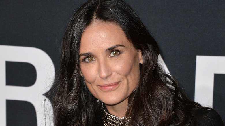 Demi Moore vêtu de noir et souriant