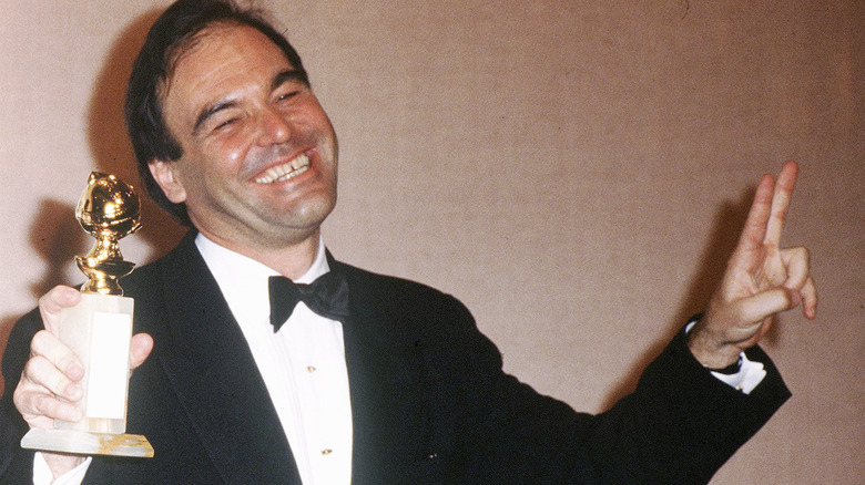 Oliver Stone souriant et tenant Golden Globe