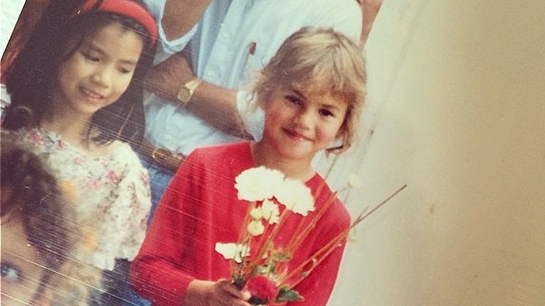 Chrissy Teigen comme une enfant tenant des fleurs