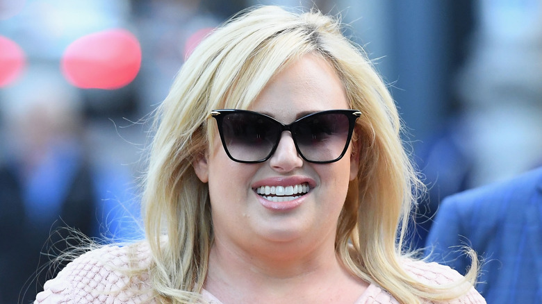 Rebel Wilson souriant et portant des lunettes de soleil