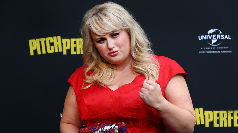 Rebel Wilson portant une robe rouge sur un tapis rouge