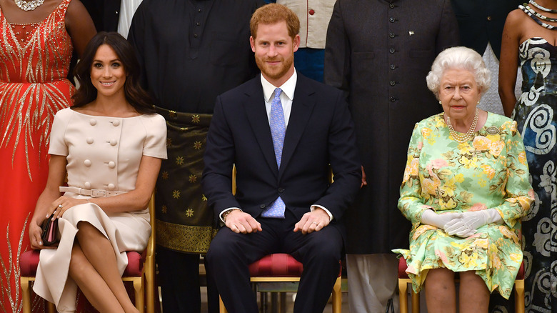 Meghan Markle, le prince Harry et la reine Elizabeth assis ensemble 