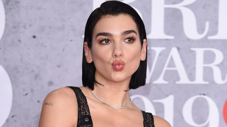 Dua Lipa plissant ses lèvres