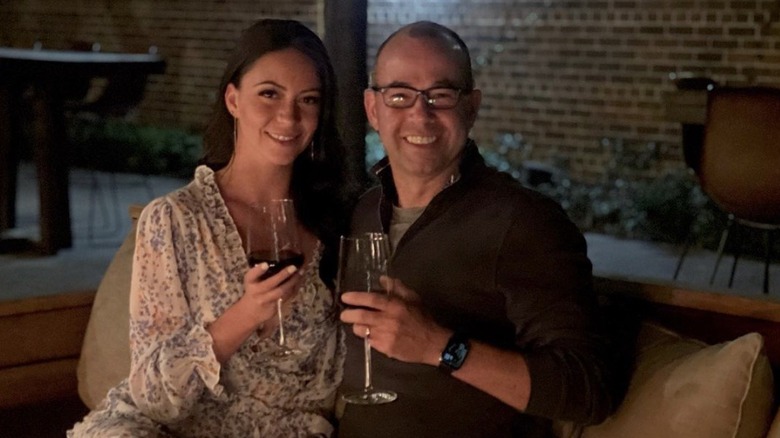 Melyssa Davies et James Murray souriant avec des verres de vin