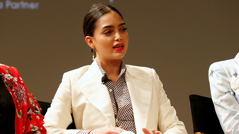 Melissa Barrera, parlant, l'air sérieux, vêtue d'un tailleur-pantalon blanc, Festival du film de Tribeca 2019