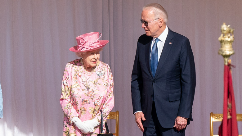 La reine Elizabeth II debout à côté du président Joe Biden sur scène