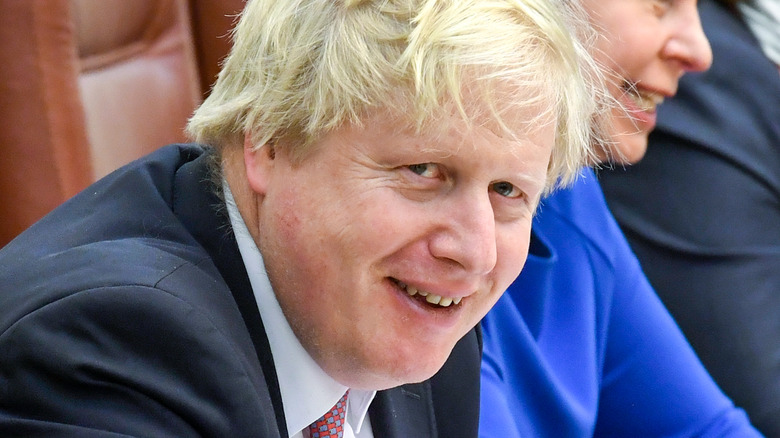 Boris Johnson assis et riant