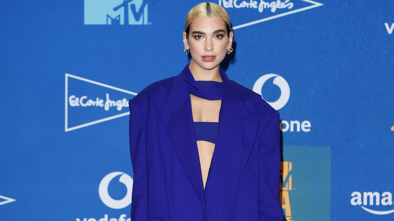 Dua Lipa sur le tapis rouge, posant toute en bleu