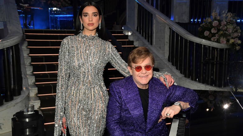 Dua Lipa posant à côté d'Elton John, assis