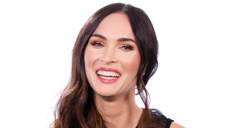 Megan Fox en train de rire dans un studio