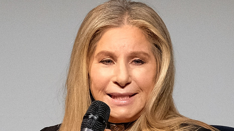 Barbra Streisand avec microphone à la main, parlant