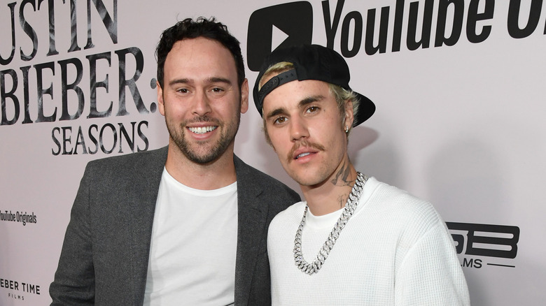 Scooter Braun et Justin Bieber souriant sur le tapis rouge 