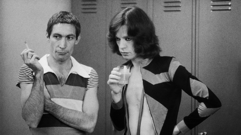 Charlie Watts et Mick Jagger, debout et écoutant