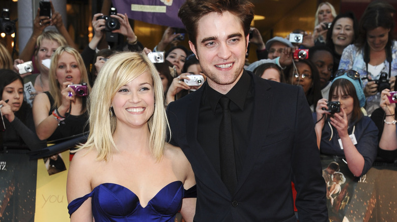 Reese Witherspoon et Robert Pattinson souriant sur le tapis rouge