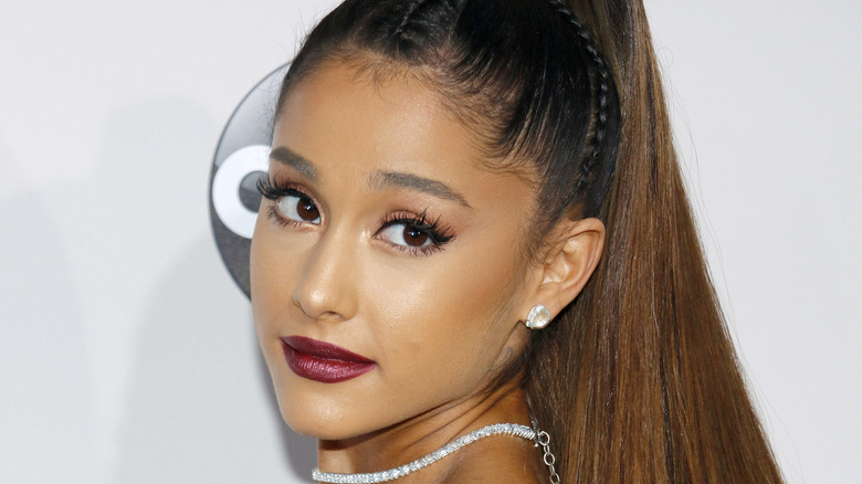 Ariana Grande regarde par-dessus son épaule