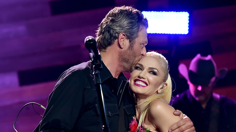 Blake Shelton embrassant Gwen Stefani lors d'une représentation en 2015