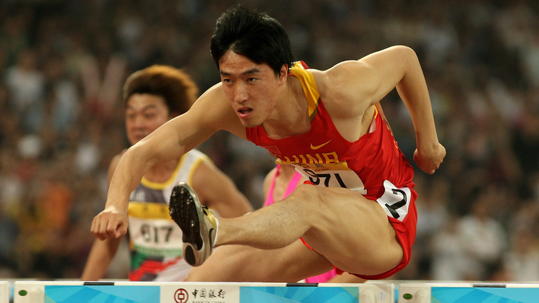 Liu Xiang sautant un obstacle