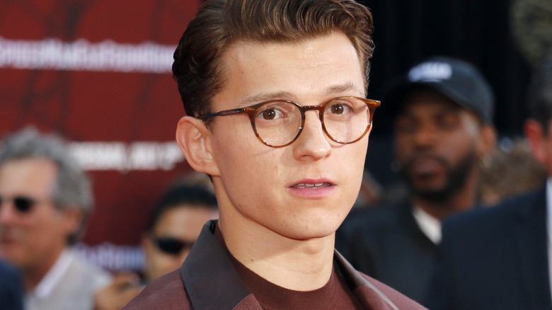 Tom Holland avec des lunettes, posant