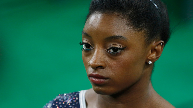 Simone Biles avec une expression sérieuse pendant la compétition