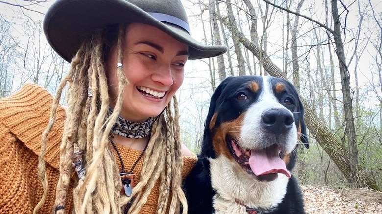 Dani Beau de Naked and Afraid souriant avec un chien