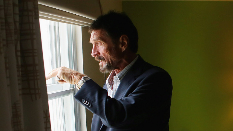 John McAfee regardant par une fenêtre