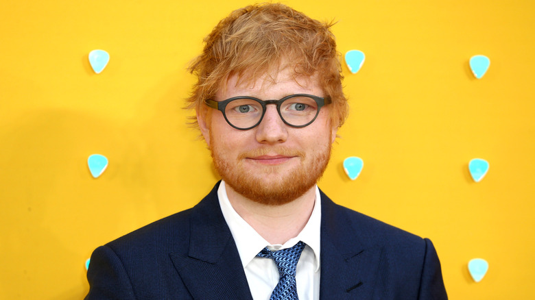 Ed Sheeran portant des lunettes sur le tapis rouge