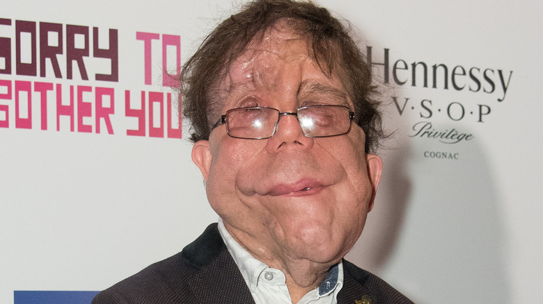 Adam Pearson smiling at a movie event 