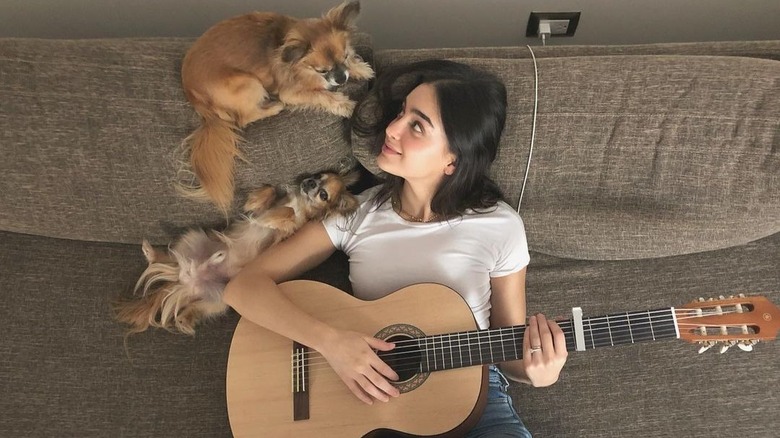 Melissa Barrera joue de la guitare, câline avec ses chiens
