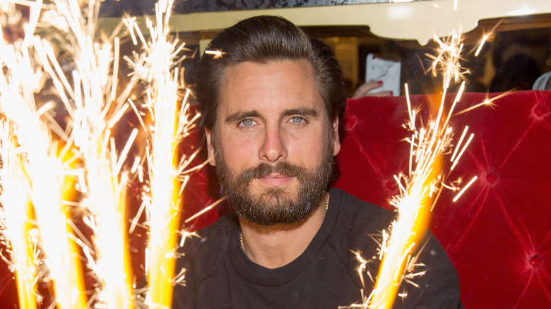 Scott Disick devant des cierges magiques