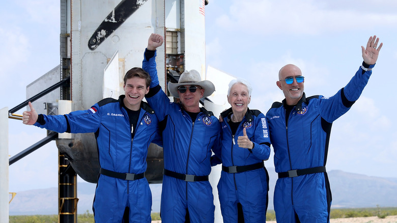 Jeff Bezos et son équipe saluant devant une fusée