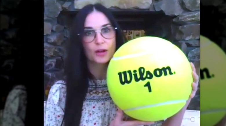 Demi Moore tenant une balle de tennis géante