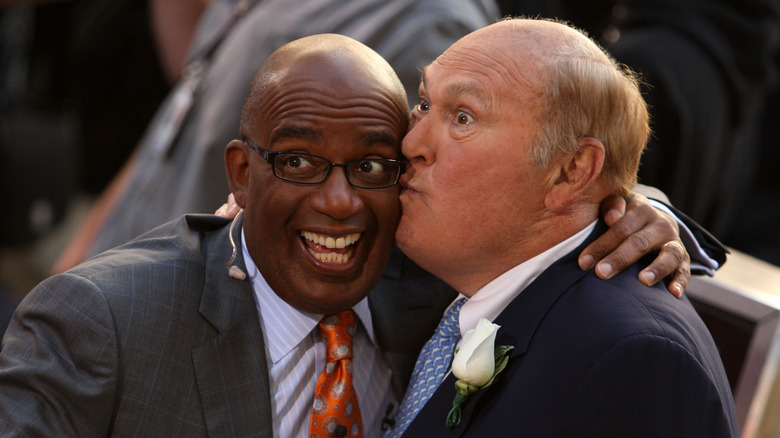 Al Roker et Willard Scott sourient et s'embrassent sur la joue