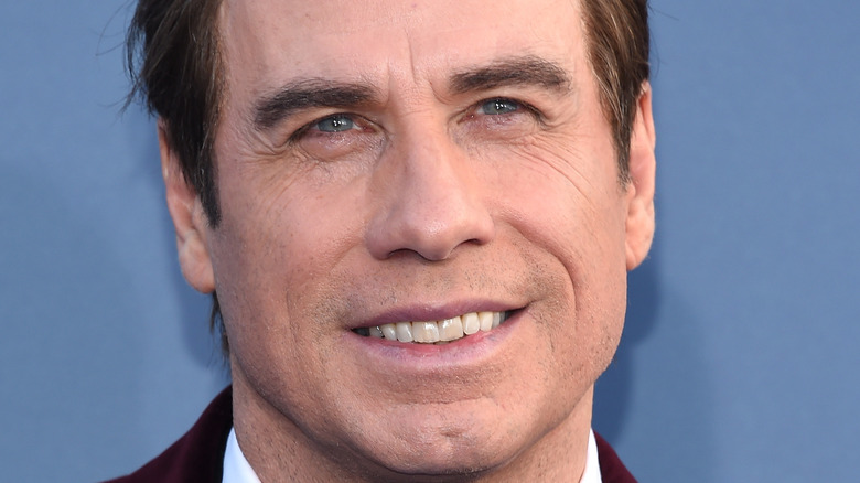 John Travolta sourit sur le tapis rouge