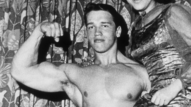 Un jeune Arnold Schwarzenegger fléchit